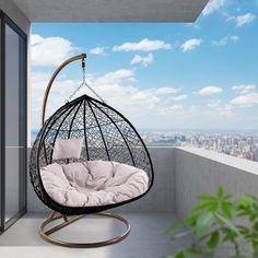 a hanging egg chair on a balcony overlooking the city