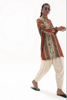 Introducing our stunning and chic two-piece kurta and pants set - a must-have addition to your wardrobe. Made from high-quality fabric, this set is designed for both comfort and style. The kurta features delicate details that add a touch of elegance to your look. The length of the kurta is just right, hitting just above the knees for a modern and sophisticated look.  The pants are designed in a straight leg style, featuring a comfortable and adjustable waistband for a perfect fit. The length is just right to complement the kurta, creating a cohesive and stylish outfit. Whether you're attending a wedding, Eid celebration, or simply want to elevate your everyday look, this set is perfect for any occasion. Pair it with your favorite accessories, shoes, and bag to create a complete look that w Bollywood Style Salwar Kameez For Navratri With Printed Motifs, Bollywood Style Printed Palazzo Set For Navratri, Bollywood Style Palazzo Set With Printed Motifs For Diwali, Bollywood Style Palazzo Set With Printed Motifs, Bollywood Style Navratri Palazzo Set With Printed Motifs, Bohemian Palazzo Set With Zari Work, Bollywood Style Long Sleeve Pant Set For Eid, Unstitched Bollywood Pant Set With Dabka Work, Traditional Long Sleeve Pant Set With Zari Work