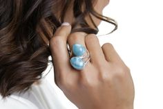 Enjoy the new collection of double stone rings is now out and about! Check these state of the art creations from one of our greatest artisans. Two stones Larimar rings so creatively made and with so much love for you to enjoy and maybe, just maybe show off a little :)  The marvelous blue Avaya Larimar ring reminds us of the beautiful and calm waters of our South beaches. Wear it and your hands will transport you to seas of tranquility. Make it yours!– Material: Larimar gemstone and 925 silver– W Elegant Blue Ring With Natural Stones, Elegant Blue Larimar Rings, Larimar Gemstone Jewelry For Wedding, Elegant Handmade Larimar Jewelry, Blue Larimar Jewelry For Anniversary, Blue Sterling Silver Fusion Rings, Elegant Larimar Rings For Anniversary, Fusion Style Blue Sterling Silver Rings, Adjustable Larimar Jewelry For Anniversary