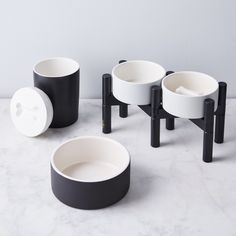 four black and white bowls sitting on top of a table