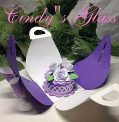 there is a cake in the shape of a bird with flowers on it and purple decorations