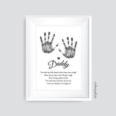 a white frame with two hands and the words daddy written on it in black ink