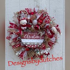 a red and white christmas wreath hanging on the side of a building with snowmen