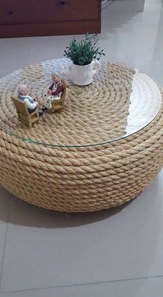 a coffee table made out of rope with a potted plant sitting on the top