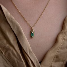 With its modern, understated style, wear this emerald set Amulet necklace for a hint of sparkle and casual luxe. Hanging from the center of the 14K yellow gold chain is a hexagon shaped pendant with two claw prongs that hug a mesmerizing green baguette cut emerald. The best part about this pendent is that it is 100% cu Minimalist Emerald Necklace In Yellow Gold, Minimalist Everyday Emerald Pendant Necklace, Yellow Gold Necklace With Emerald Rectangular Pendant, Gold Emerald Cut Emerald Necklaces, Emerald Cut Gemstone Necklace In 14k Gold, Everyday Yellow Gold Emerald Necklace For May Birthstone, Dainty Emerald Cut Yellow Gold Necklace, Minimalist 14k Gold Emerald Gemstone Necklace, Minimalist 14k Gold Emerald Necklace