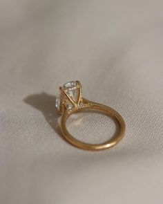 a diamond ring sitting on top of a white cloth