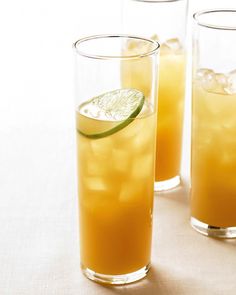 three glasses filled with drinks and garnished with lime