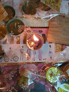 a table topped with lots of different types of food and candles on top of it