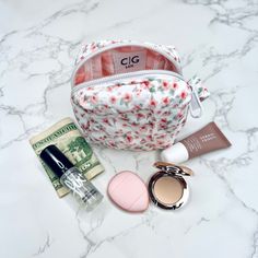 the contents of a cosmetic bag on a marble surface