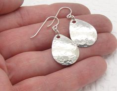 "These lightweight small hammered teardrop earrings are made from solid sterling silver. We have four sizes of tear drop earrings, and these are the small, 1-1/4 inch long size. I have textured them with a hammer, cupped them to give them a bit of a dome shape, and tumble polished them for shine and strength. These earrings are hung with several extra links. The links make the teardrops move gracefully and fit more comfortably. The widest part of the teardrop is about a 3/4\" (17 mm) and the len Hammered Long Drop Teardrop Earrings As Gift, Hammered Teardrop Jewelry For Gift, Teardrop Hammered Jewelry For Gift, Hammered Teardrop Earrings, Hammered Long Drop Teardrop Earrings For Gift, Teardrop Hammered Jewelry Gift, Silver Drop Hammered Jewelry, Hammered Teardrop Earrings For Anniversary, Hammered Drop Sterling Silver Jewelry