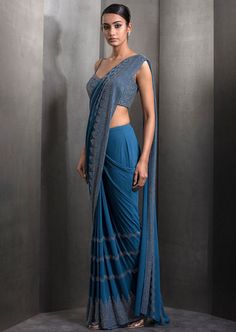 Draped pre-stitched tulle sari embellished with tonal embroidery with matching embroidered blouse. Semi-stitched Embellished Blue Blouse Piece, Semi-stitched Embellished Blue Saree, Blue Pre-draped Saree With Zari Work For Evening, Blue Bollywood Embellished Pre-draped Saree, Embellished Blue Saree For Diwali, Evening Blue Pre-draped Saree With Zari Work, Blue Embellished Floor-length Saree, Festive Blue Embellished Pre-draped Saree, Blue Zari Work Party Wear Pre-draped Saree