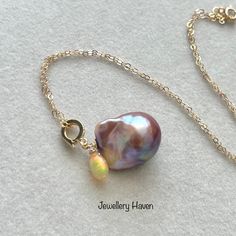 Ready to Ship. Handmade in Singapore. High quality natural Gemstones are used: - Metallic iridescent purplish baroque pearl (19x16mm) - flashy Ethiopian Opal briolette Metal components:- - high quality gold vermeil bail components and 14k gold filled chain. Measurements: - 16 inches 14k gold filled chain.  Thank you for shopping at Jewellery Haven! SHIPPING This item ships by FedEx courier for International shipping.  Free Smartpac delivery for addresses in Singapore. *Important* Prices are set High Luster Briolette Pearl Necklace As Gift, Baroque Pearl Briolette Jewelry For Gifts, High Luster Briolette Pearl Necklace For Gift, Briolette High Luster Pearl Necklace Gift, Elegant Iridescent Pearl Necklace For Gift, Purple Pearl Chain Jewelry For Gift, Iridescent Pearl Pendant Jewelry Gift, Adjustable Baroque Pearl Pendant Jewelry, Adjustable Gold Baroque Pearl Necklace