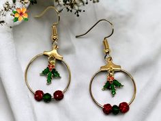 Get into the holiday spirit with our Mistletoe Earrings! Handmade and featuring a mistletoe charm, these earrings are perfect for all your Christmas festivities. The dangle design includes red rhinestone beads and a green bead on gold hoops, adding a touch of festive color to your outfit. Whether you're dressing up for a holiday party or simply adding some cheer to your everyday look, these earrings are sure to bring a smile to your face. Order yours today and spread the holiday cheer Mistletoe Earrings, Christmas Festivities, Cat Bracelet, Star Bracelet, Red Rhinestone, Rhinestone Bead, Moon Earrings, Gold Hoops, Green Bead