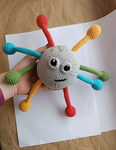 a hand holding a crocheted toy that looks like a spider