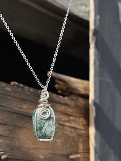 This beautiful silver pendant features a polished Moss Agate Crystal! The pendant was handcrafted by Holly from Tumbled Shop using sterling silver plated wire. Moss Agate speeds up recovery from any illnesses. Moss Agate puts up shields offering you and your aura protection. This protection allows you to feel safe to be the true version of you! It makes you realize that there is happiness and joy all around us through life, friends, family and animals! This comfort allows us to go back to our ro Silver Moss Agate Pendant Necklaces, Silver Moss Agate Necklaces As Gift, Silver Moss Agate Necklaces For Gifts, Silver Moss Agate Necklace As A Gift, Silver Moss Agate Pendant Necklace, Unique Moss Agate Silver Necklace, Sterling Silver Pendant Crystal Necklace With Gemstone Beads, Unique Silver Moss Agate Necklace, Wire Wrapped Ocean Jasper Pendant Jewelry