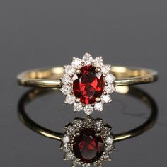 Natural Garnet Ring, Vintage Garnet Halo Ring, Garnet Wedding Ring, 14k Gold Garnet Ring, Cluster Ring, January Birthstone Ring, Gift Her -------------------------------------------------------------------------------------------------------------------------------------------------------------------------------------------------------------- * Metal : 925 Sterling Silver / 10k / 14k Solid Gold * Gemstone  Stone : Garnet * Shape  : Oval * Size : 5x7MM * Weight : 0.86 Ct ( Approx. )  \ * Side Stone : Moissanite  * Clarity : Eye Clean * Personalization : Possible * Occasion : Party , Anniversary , Wedding Sent in a very elegant wedding ring box, ready for one special lady. Customization is always welcome and please feel free to contact with me if you have any design ideas! Thank You....:) Garnet And Diamond Engagement Ring, Red Gold Ring, Red Cluster Rings With Brilliant Cut, Gold Garnet Cluster Promise Ring, Halo Ruby Ring For Promise, Round Cut, Halo Round Cut Ruby Promise Ring, Round Cut Ruby Ring With Halo For Promise, Halo Ruby Promise Ring Round Cut, Round Cut Halo Ruby Promise Ring