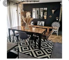 a dining room table with chairs and pictures on the wall in front of an open window