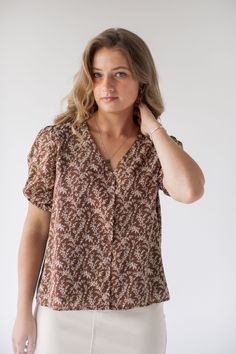 Introducing the 'Sabrina' button down top – a delicate and charming addition to any ensemble. This top is adorned in a ditsy floral pattern that is simple yet stunning! Pair with a pencil skirt and low heels for a simple and sophisticated office look. 100% Polyester Lined Hand Wash Cold Hang or Lay Flat to Dry Do Not Bleach Cool Iron If Needed Functional, nursing friendly buttons! Model Height 5'7" | Wearing Size Small Wearing the 'Sabrina' Ditsy Floral Button Down Top in Brown and the 'Sara' St Brown V-neck Blouse With Button Closure, Feminine Ditsy Floral Print Summer Blouse, Feminine Floral Print Blouse For Daywear, Feminine Blouse With Ditsy Floral Print, Feminine Brown Tops For Spring, Feminine Ditsy Floral Print Blouse For Daywear, Feminine Ditsy Floral Print Tops For Daywear, Trendy Ditsy Floral Print Blouse For Spring, Spring Brown Button-up Top