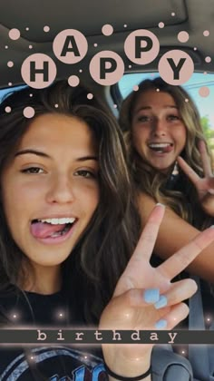 two girls in a car making the peace sign with their hands and smiling at the camera