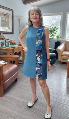 a woman standing in a living room next to a couch