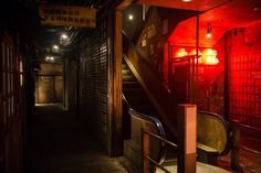 an alleyway with stairs and red lights in the dark, at night or day