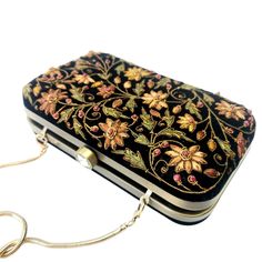 "Beautiful designer luxury black velvet hard case clutch bag, hand embroidered with a rich palette of caramel colored flowers and embellished with ruby gemstones. This will be your go to purse for any wedding! A classic design that never goes out of style. Expertly hand embroidered by third generation zardozi artisans. The word Zardozi means \"gold thread\". It is an elaborate and intricate multidimensional embroidery using metallic threads and genuine precious and semi precious gemstones. A cen Bride Purse, Embellished Purses, Floral Handbags, Velvet Clutch, Types Of Gifts, Wedding Purse, Wedding Clutch, Party Purse, Girls Handbags