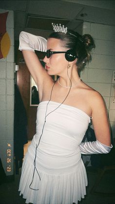 a woman in a white dress with headphones and a tiara on her head