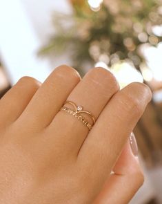 Rei features a dainty wishbone-shaped band with a petite clear cubic zirconia stone in the center. She's a beautiful stacking ring that can elevate the other rings. Made in 14k gold-fill, she's tarnish-resistant, showerproof, and safe for sensitive skin. Just keep her away from chemicals such as hand sanitizer, soap, and lotion. …………………………………. D E T A I L S • Available from US 5 to 8• Band measures 1mm, cubic zirconia stone measures 2mm• Keep away from chemicals such as lotion, soap, and hand sa Dainty Stackable Open Band Rings For Promise, Dainty Rose Gold Cubic Zirconia Midi Rings, Adjustable Dainty Diamond Ring With Open Band, Adjustable Open Band Dainty Diamond Ring, Dainty Stackable Cubic Zirconia Midi Rings, Dainty Diamond White Stackable Promise Rings, Delicate Promise Stackable Rings With Diamond Accents, Dainty Midi Rings With Diamond Accents, Dainty Adjustable Diamond Ring With Vs Clarity