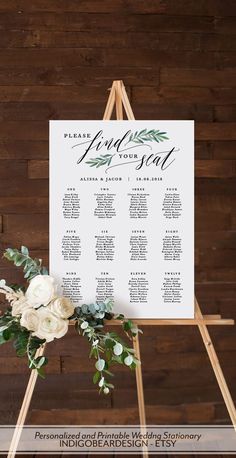 an easel with flowers and greenery on it is displaying the seating for a wedding