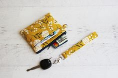 a wallet and keychain are sitting on the floor next to each other with keys in it