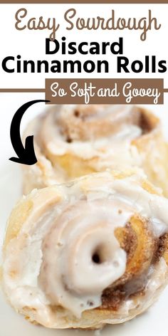 two cinnamon rolls with icing on top and the words easy sourdough discard cinnamon rolls so soft and gooey