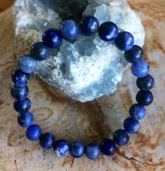 This is an all natural, premium quality Blue Sodalite stretch bracelet!  These amazing beads consist of sky blue, white and indigo swirled together. Blue Sodalite is a powerful healing stone used to bring calm energy and emotional balance. It can also be used to bring confidence and intuition. Throat Chakra is for communication and confidence. The Third Eye Chakra aids in psychic abilities and dream enhancement.  Click here to check out the rest of my handmade gemstone bracelets: https://www.etsy.com/shop/honestgems?section_id=21516055 Please contact me if you are interested in custom bracelets for wedding parties, birthdays, etc. I just recently made matching bracelets for every guest at a wedding! It's a great take-home for such a memorable and beautiful ceremony! All of the accent beads Blue Spiritual Stretch Bracelet For Meditation, Blue Casual Bracelet For Meditation, Casual Blue Bracelet For Meditation, Spiritual Blue Lapis Lazuli Beaded Bracelets, Blue Spiritual Stretch Bracelet With Round Beads, Blue Round Spiritual Stretch Bracelet, Blue Natural Stones Beaded Bracelets For Meditation, Blue Adjustable Stretch Bracelet For Healing, Adjustable Blue Stretch Bracelet For Healing