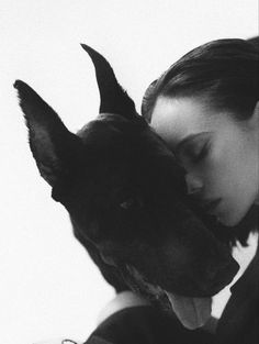 a woman is hugging her dog in black and white