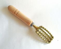 a wooden spatula with metal handles on a white surface