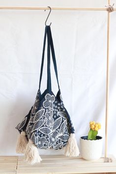 This handmade shoulder bag is a true piece of art, featuring intricate hand-stitching a unique bohemian design, and a four-sided (tetrahedral) base, giving it a distinct and geometric look. Crafted with care by our artisans. This bag is perfect for anyone who loves unique and beautiful accessories.  With its charming tassels and original design, this bag is sure to be a standout addition to any wardrobe. Unique Design: Every bag boasts a distinct pattern, with subtle variations in details, makin Bohemian Tote Bucket Bag With Tassels, Bohemian Bucket Bag With Tassels For Daily Use, Bohemian Blue Hobo Tote Bag, Bohemian Bucket Bag Tote With Tassels, Bohemian Bucket Tote Bag With Tassels, Bohemian Hand-stitched Bags, Bohemian Hand-stitched Rectangular Shoulder Bag, Bohemian Blue Embroidered Shoulder Bag, Blue Bohemian Crochet Shoulder Bag