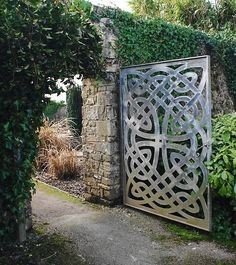 an iron gate in the middle of a garden