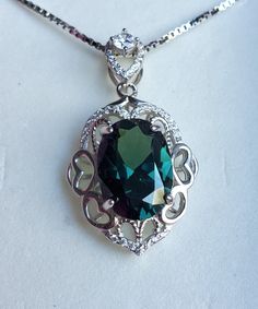 "Gorgeous Color-Change Alexandrite 10x14mm 7 Carat Simulated Lab Created Gem, Watch Video As Gem Changes From Purple In Incandescent Lighting, To Teal Green In Natural Light, See Video! 925 Sterling Rococo Heart Design Pendant With Pave' Cubic Zirconias, 20\" Sterling Chain. Gift Box Included. *Color Change Affects Vary Depending On Lighting" Luxury Sterling Silver Oval Pendant Jewelry, Elegant Jewelry With Sterling Silver Clasp And Oval Pendant, Classic Silver Necklace With Emerald, Classic Silver Emerald Necklace, Silver Oval Pendant With Emerald, Elegant Green Necklace With Sterling Silver Clasp, Gem Watch, Incandescent Lighting, Watch Necklace