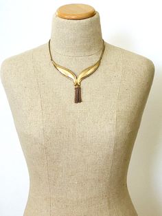 Vintage Modernist Collar Necklace with Tassel Pendant Gold Tone AdjustableA gorgeous vintage Mod/Modernist necklace in yellow gold plated metal. It is shaped as two wings that meet at the center, finished by a chain tassel to give it movement.The 14 strand chain tassel drop at the center measures 4 1/4" wide at the chain and 4 inches tall overall.In excellent condition, this vintage Mod Modernist collar necklace with tassel pendant in gold tone metal has an adjustable length from 17 to 19 inches Gold Tassel Necklace With Fringe For Gift, Elegant Gold Necklace With Tassels, Gold Fringe Metal Necklaces, Gold Fringe Metal Necklace, Gold Fringed Long Necklace, Gold Fringe Long Necklace, Gold Long Fringe Necklace, Jewelry Charms Pendants, Current Styles