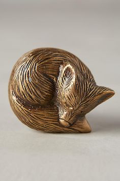 a small bronze cat figurine sitting on top of a table