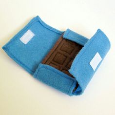 a small blue felt case with a brown door in it on a white table top