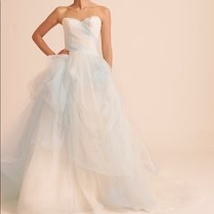 a woman in a white wedding dress posing for the camera with her hands on her hips