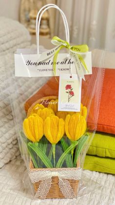 a basket filled with yellow tulips sitting on top of a bed