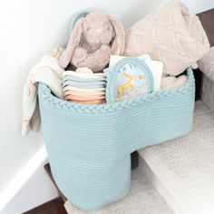 a blue basket filled with blankets and toys