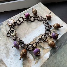 * This beauty is perfect for that autumn walk! I added several adorable charms: lovely purple and earth colored hue beads by artist Humblebeads and lovely gold washed acorn beads (Czech glass).  * SIZE: Bracelet fits size 6 to 7 and 1/2 inch wrist. I can size up easily just message me! * Designed in Poestenkill NY * NOTE: Wearing in water or to the gym is not recommended  * NOTE:  As with most jewelry , do not force an adjustment if a section becomes mis-aligned. Just give a gentle tug or wiggle and it will straighten out easily. * DISCLAIMER: other items used in photo are not for sale, nor are they included in any purchase. Rustic Bracelet, Autumn Walk, Autumn Bracelet, Gold Wash, Just Giving, In Water, Czech Glass, Arm Band, Halloween Shopping