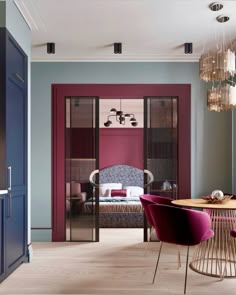 a living room filled with furniture and a chandelier hanging from the ceiling next to a dining table