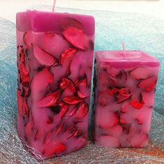 two pink candles sitting next to each other on a table