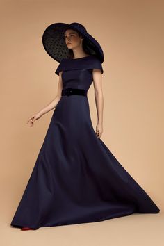 a woman in a long blue dress and hat