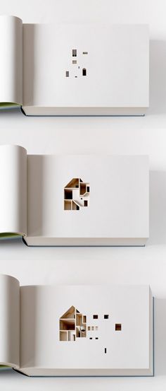 three open books with cut out houses on them