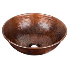 a round copper sink with an intricate design on the bowl, and a drain hole in the center