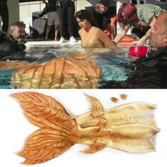 some people are in the water and one is holding a fish shaped like a goldfish